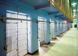Description: Interior view of correctional facility with barred doorways.