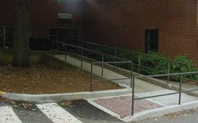 Description: Ramped sidewalk access with handrails.